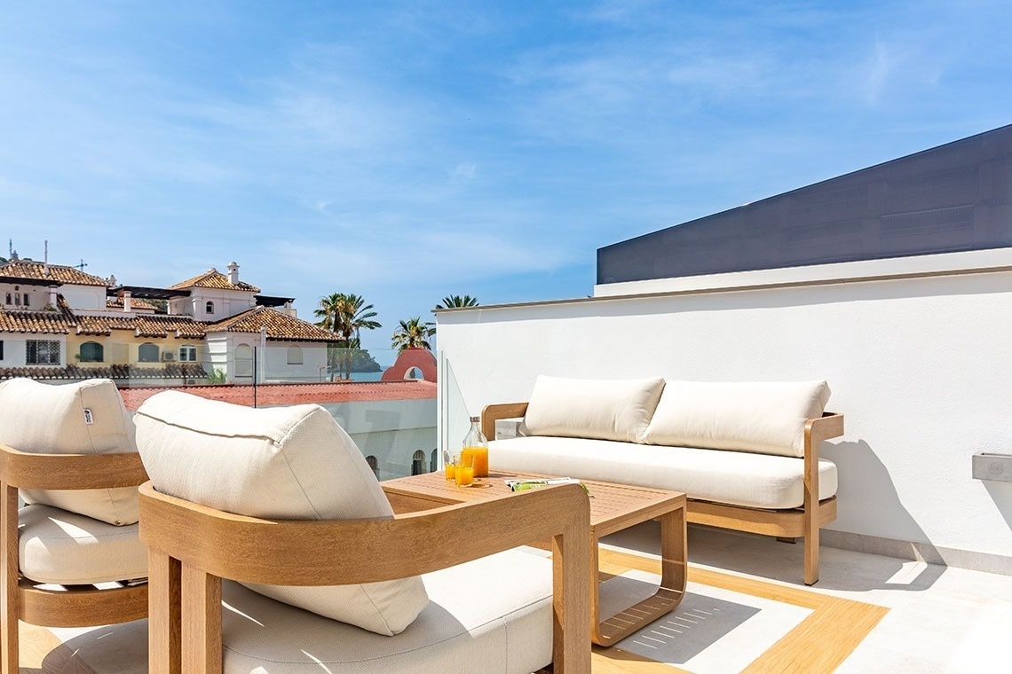 una terraza con muebles y una mesa con una botella de jugo de naranja