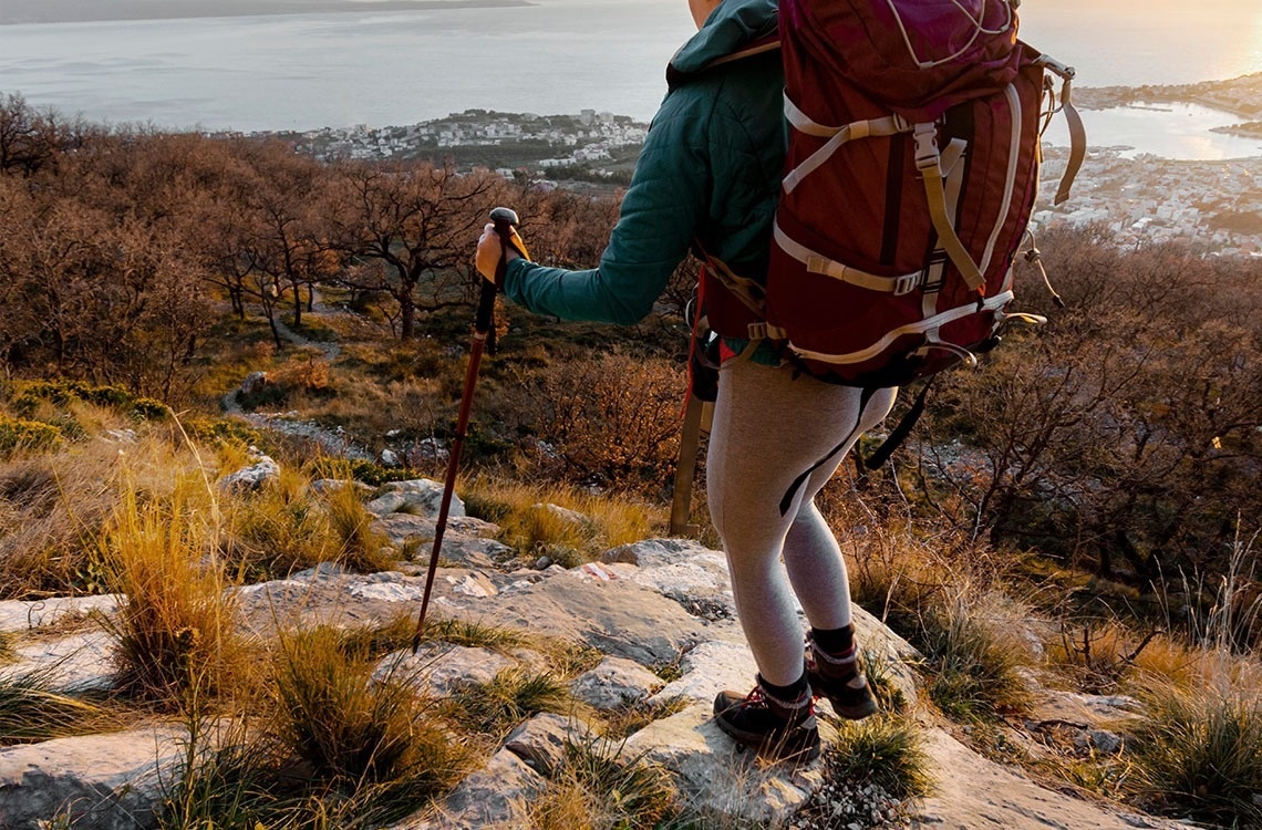 un hombre y una mujer caminan por un camino de piedra junto a una montaña