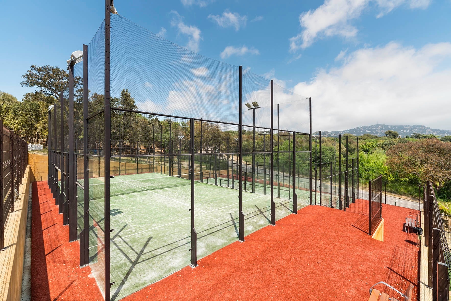 una cancha de padel con una red negra alrededor