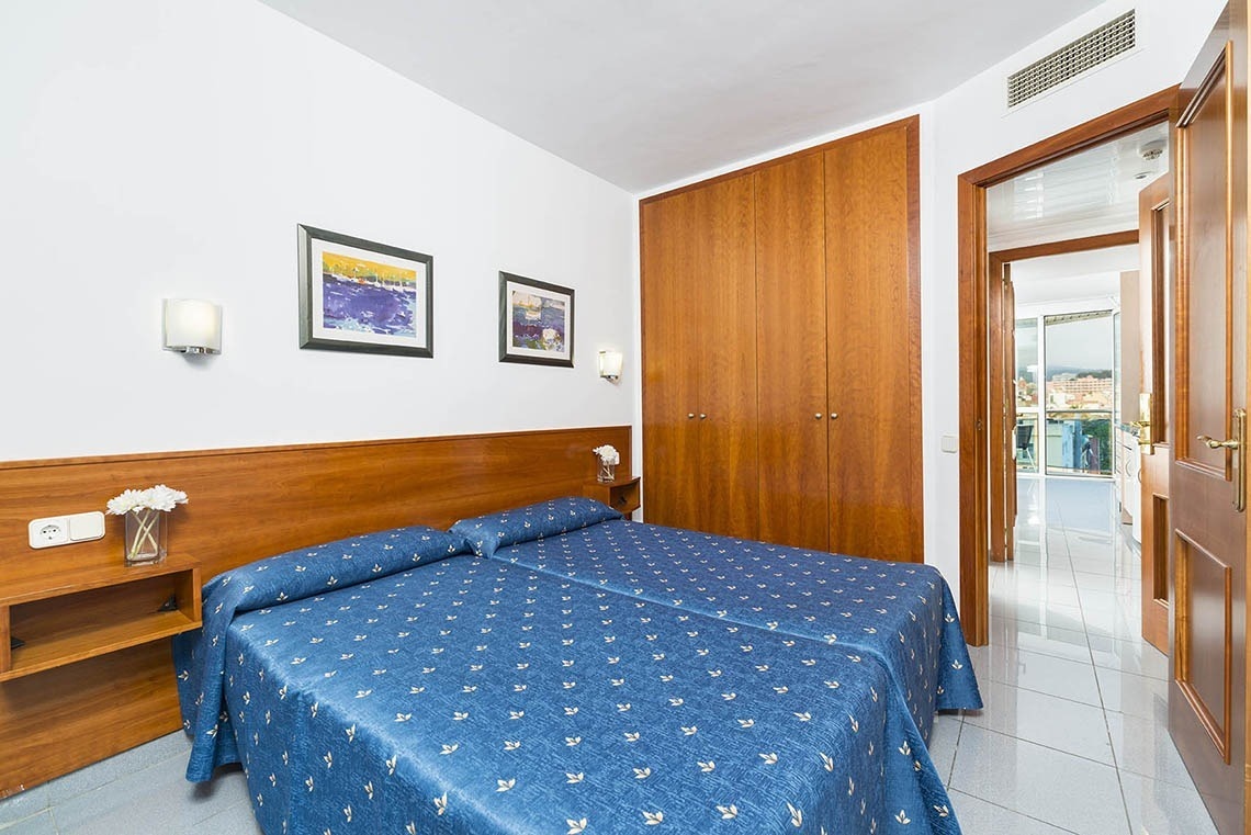Habitación doble azul con armario de madera en Apartaments Blau, Lloret de Mar | Marsol Hotels.
