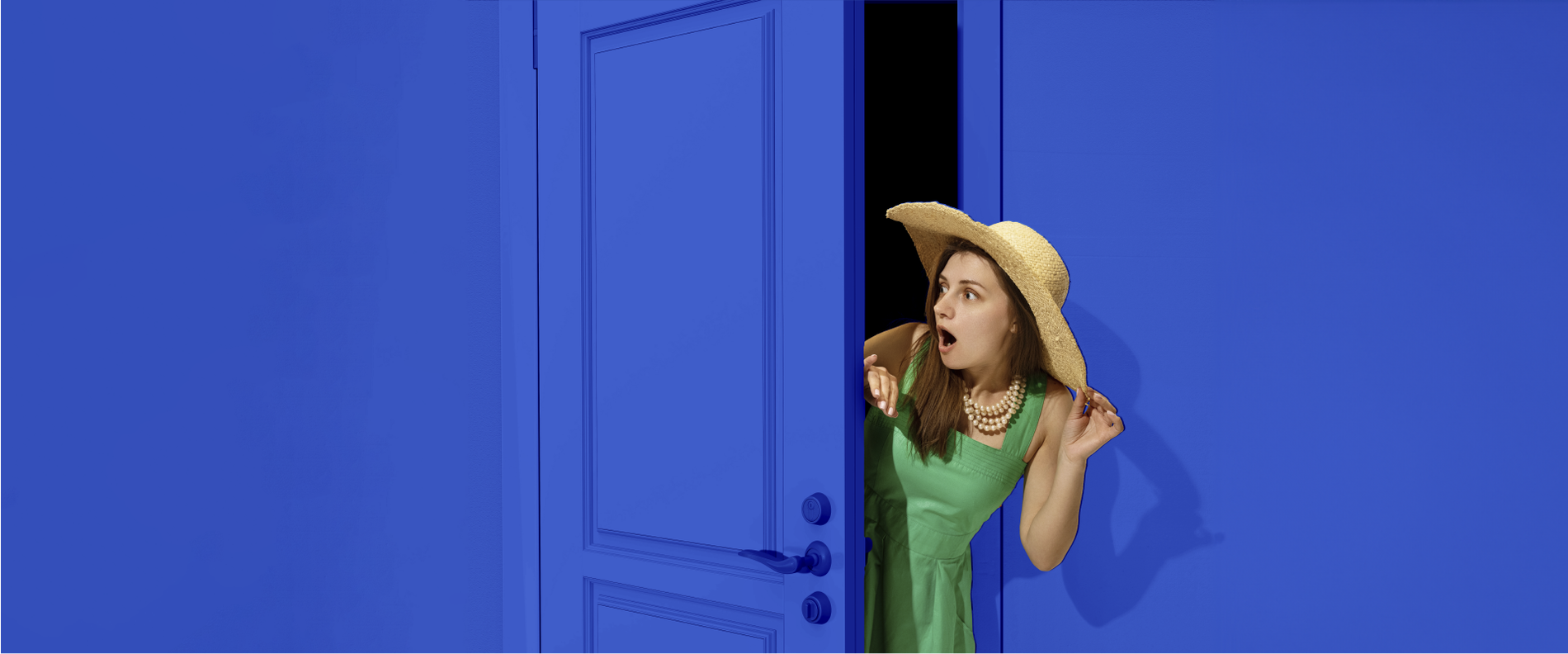 a woman in a green dress and straw hat is peeking out of a blue door