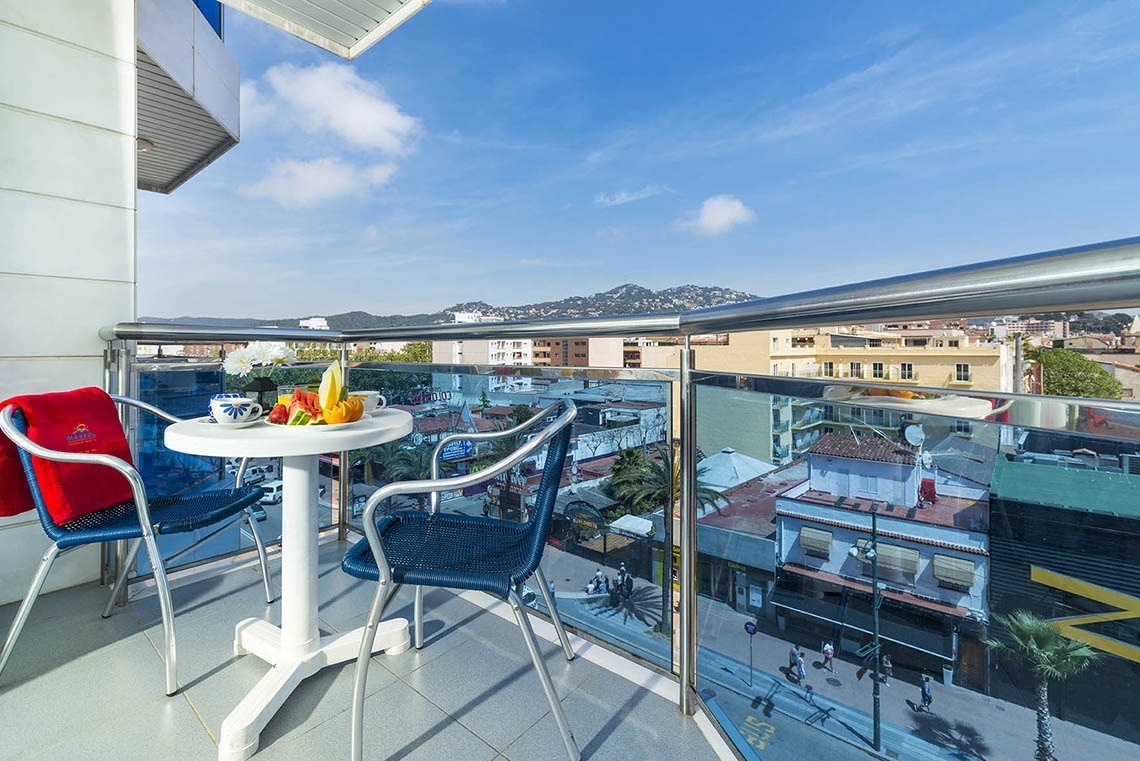 Balcó amb taula i fruita amb vista a la ciutat, ideal per a Apartaments Blau a Lloret de Mar | Marsol Hotels & Resorts.