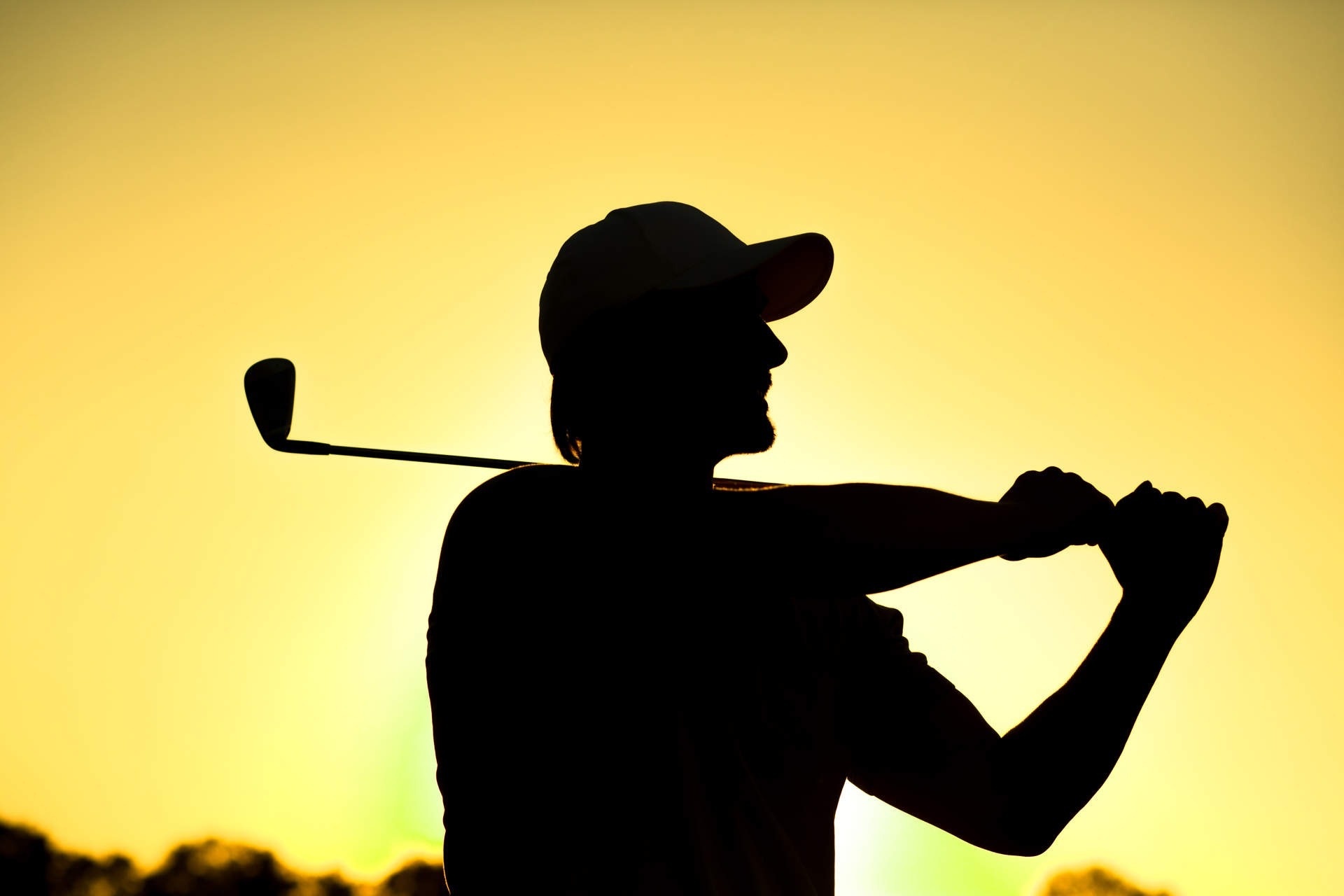 eine Silhouette eines Mannes mit einem Golfschläger auf dem Rücken