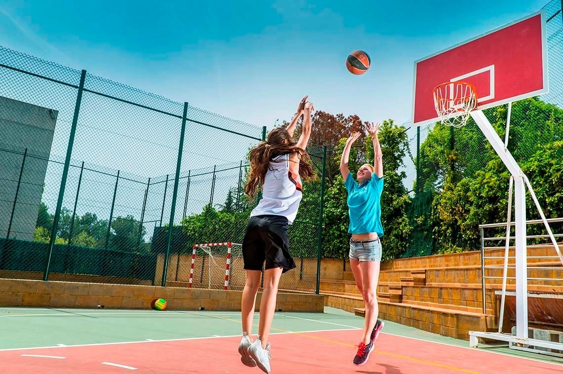 dos joves jugant a un partit de basquetbol