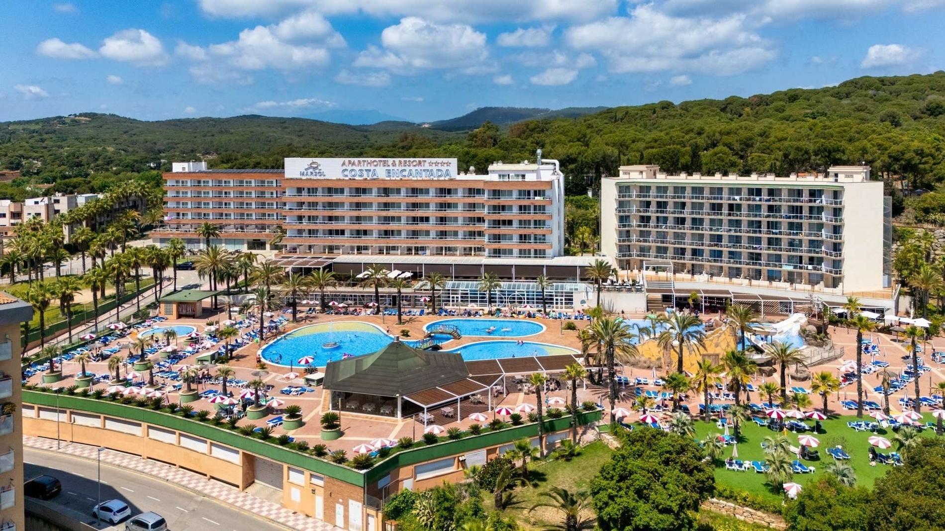 a large hotel with a large pool in front of it