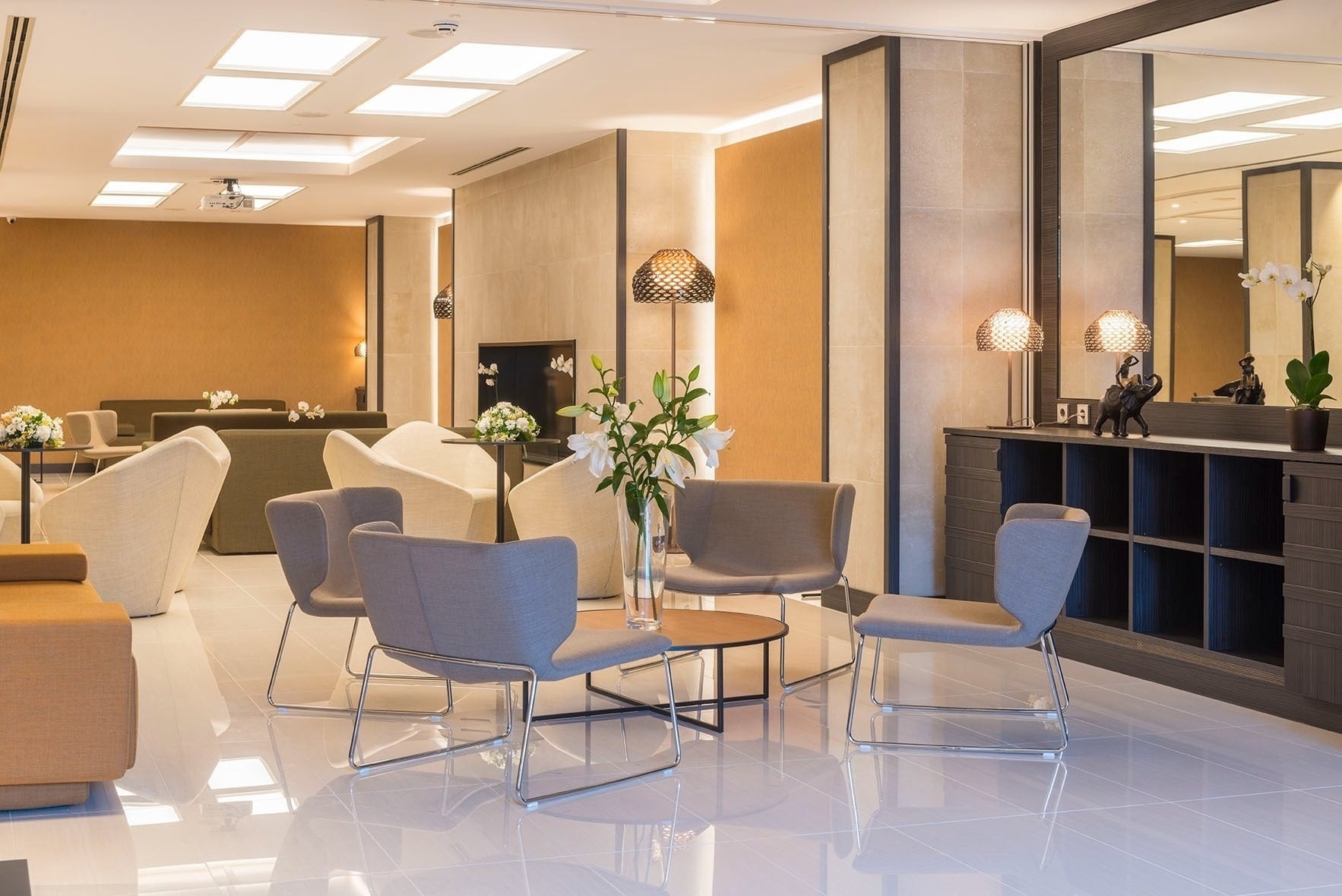 Un espai d'estar modern i elegant, amb seients còmodes, terres brillants i decoració cuidada.