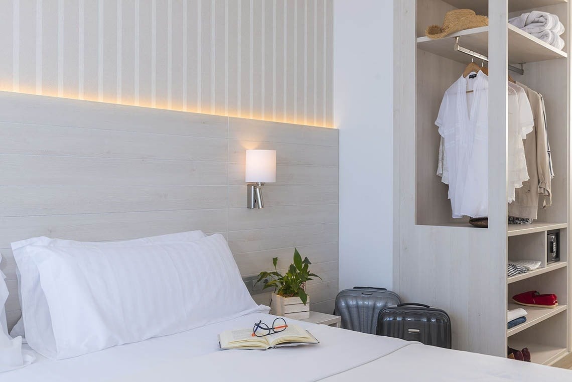 Habitación moderna en Hotel Marsol con armario abierto y equipaje. Hotel Marsol | Marsol Hotels & Resorts en Lloret de Mar.