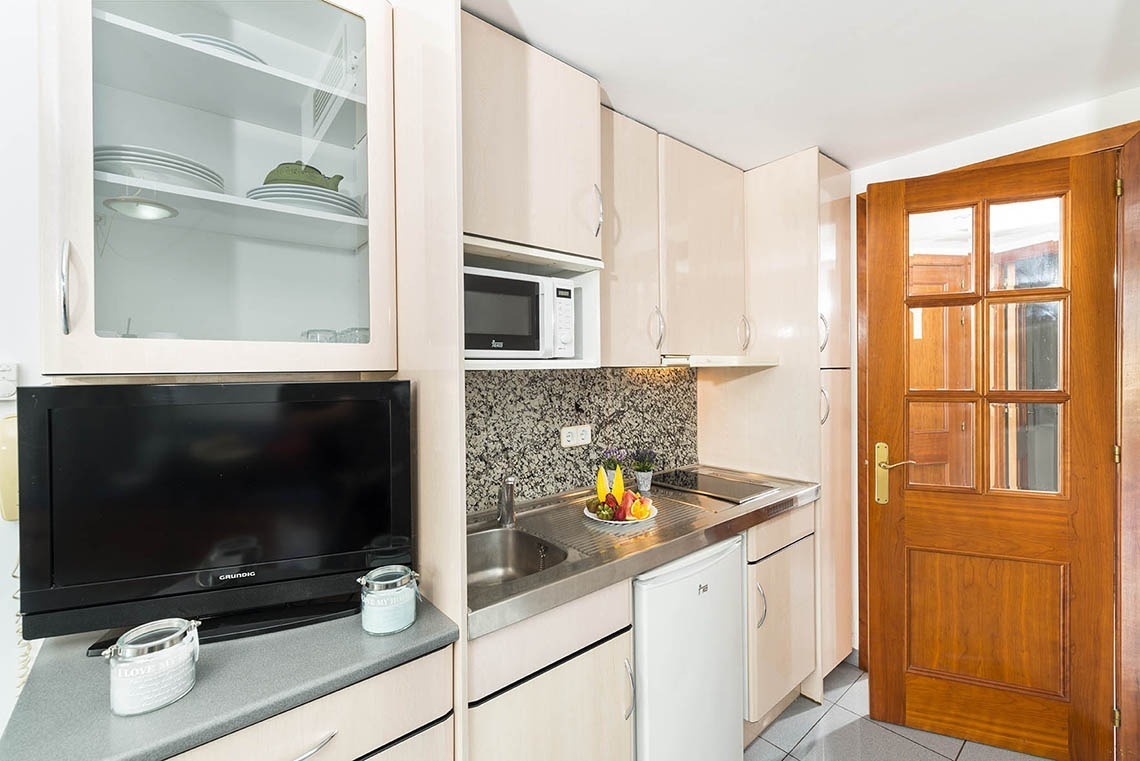 Cuina d'apartaments a Lloret de Mar: microones, nevera petita i vaixella. Ideal per a estades a Apartaments Blau.
