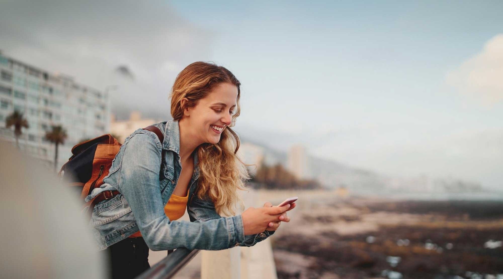 Femme souriante utilisant son téléphone à l'hôtel Marsol: Corporatif