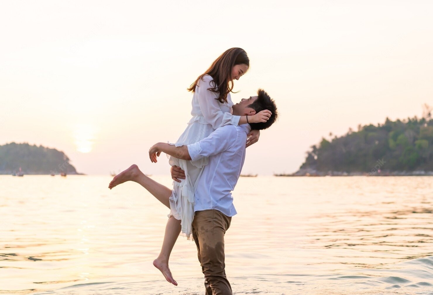 a man is holding a woman in his arms in the water