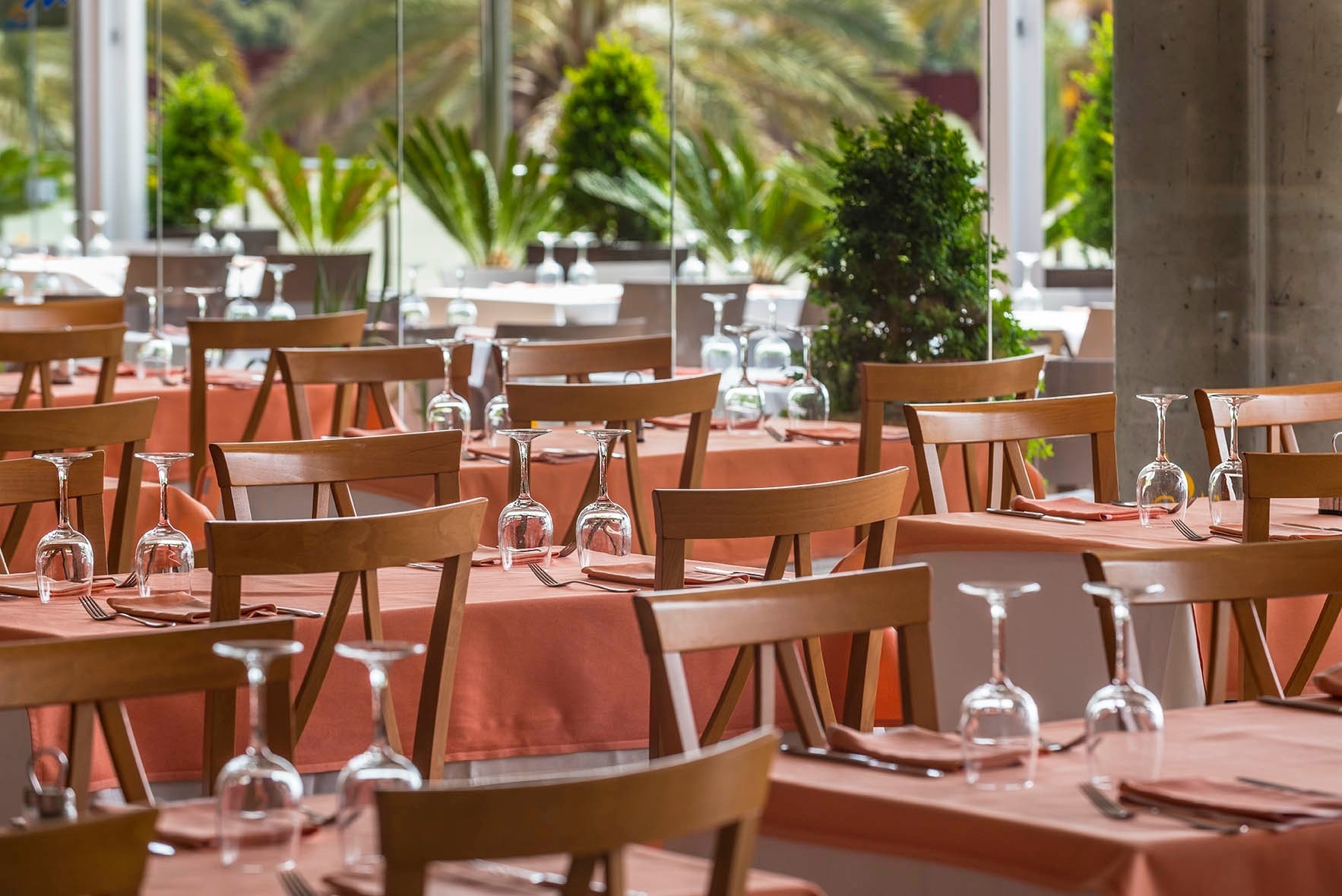 un restaurante lleno de mesas y sillas y copas de vino