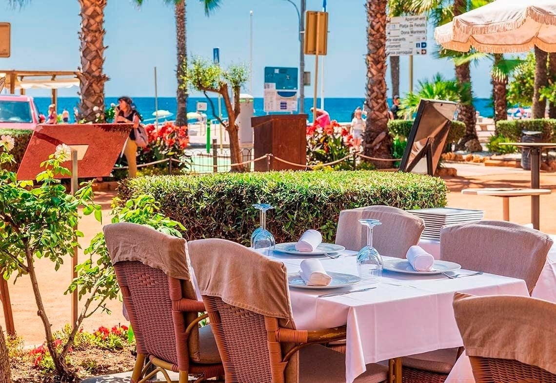 Terraza de Hotel Marsol con mesas listas junto al mar en Lloret de Mar.