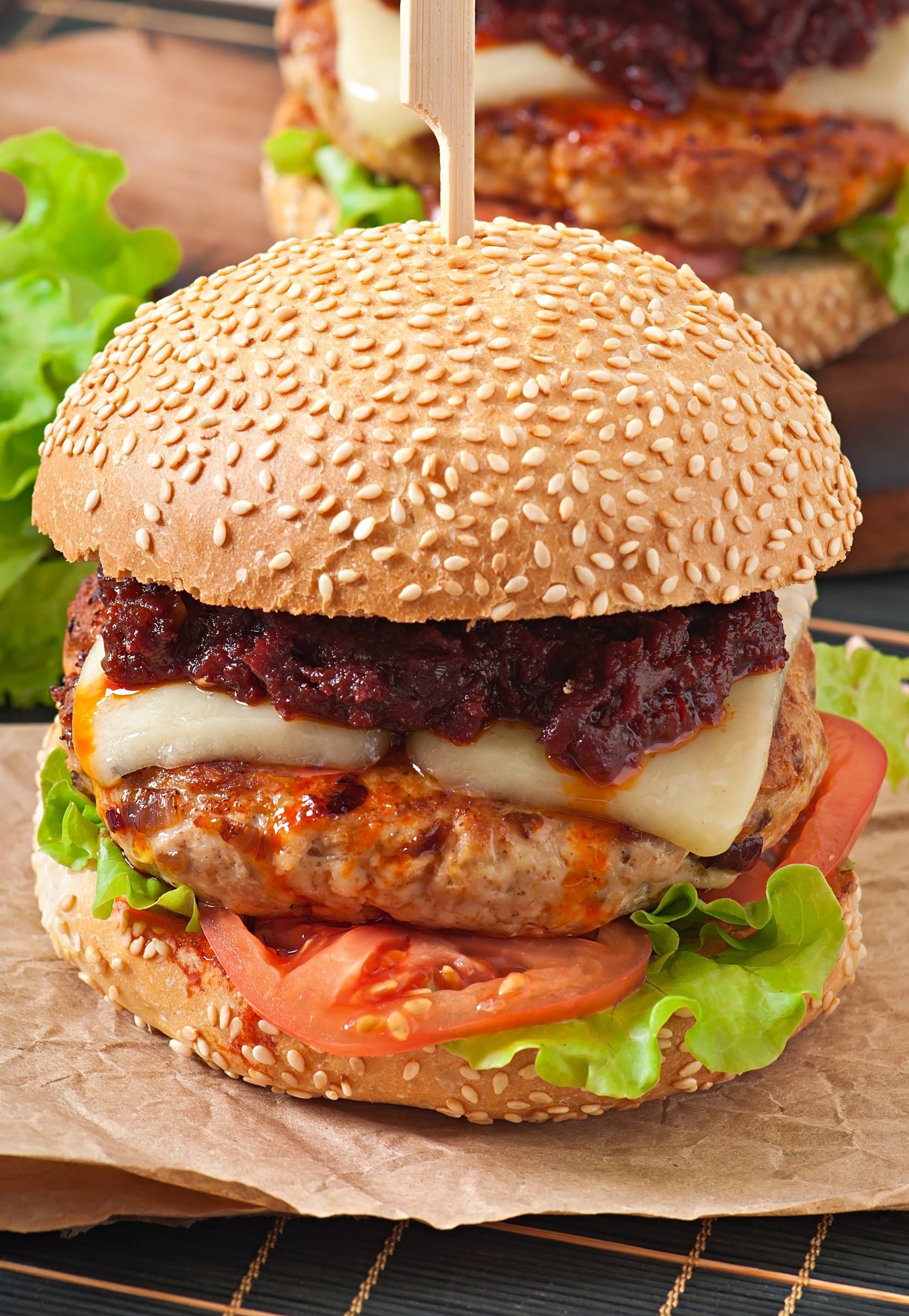 ein Cheeseburger mit Salat und Tomaten auf einem Sesambrötchen