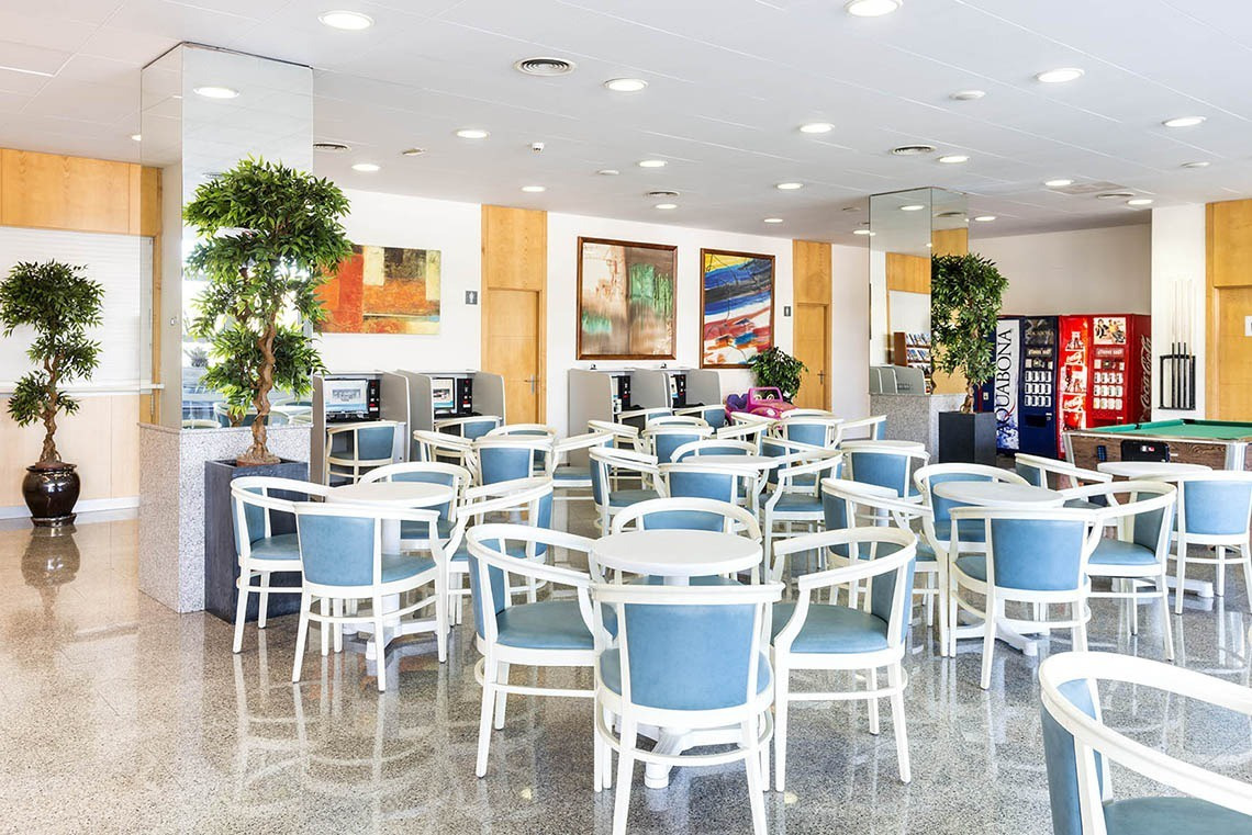 Saló d'estar modern amb taules i cadires blaves als Apartaments Comtat a Lloret de Mar | Marsol Hotels & Resorts.