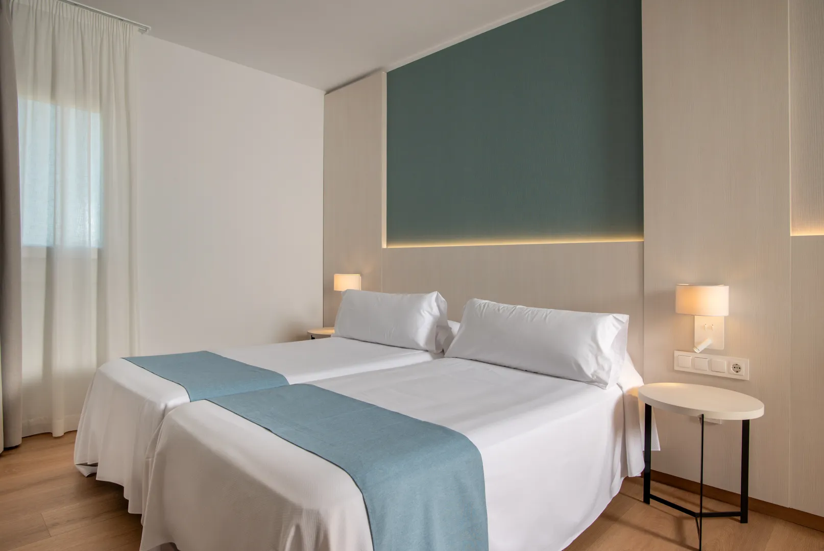Habitación doble con Costa Encantada Suites & Resort camas individuales, ropa de cama blanca y acentos azul claro.
