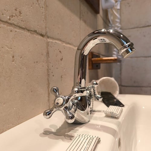 a bathroom sink with a faucet and a toothbrush on it