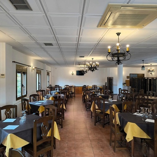 a restaurant with tables and chairs and a chandelier hanging from the ceiling