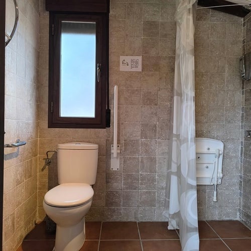 a bathroom with a toilet and a shower curtain