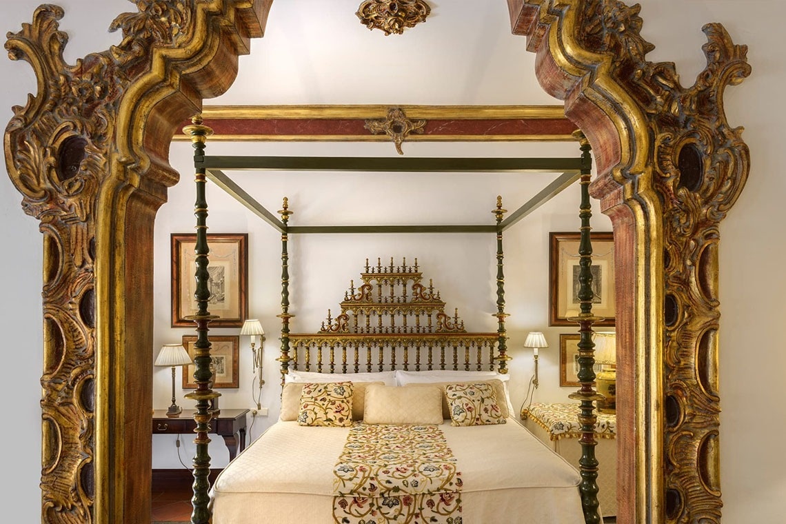 a bedroom with a canopy bed and a mirror