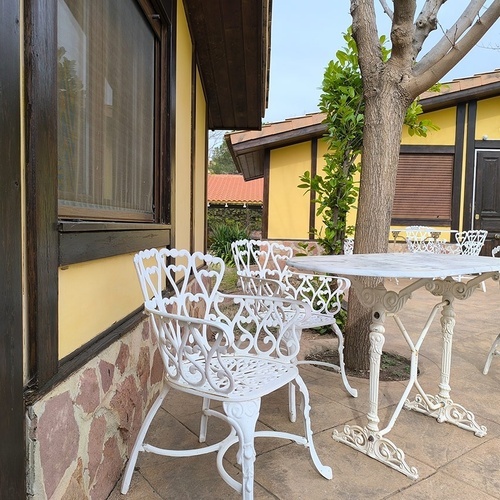 a table and chairs outside of a yellow building