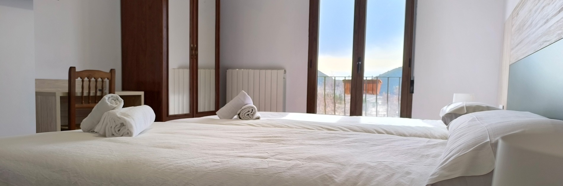 a hotel room with two beds and a balcony