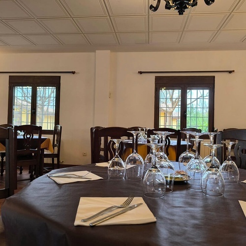 una mesa llena de copas de vino y cubiertos en un restaurante