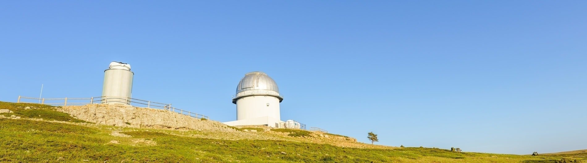 a large white building on top of a grassy hill