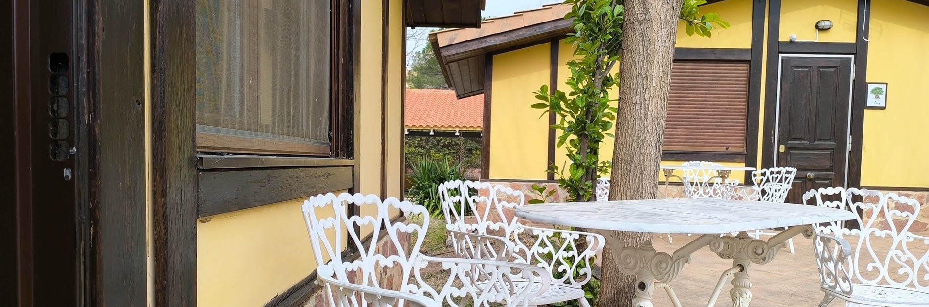 a white table and chairs in front of a yellow building