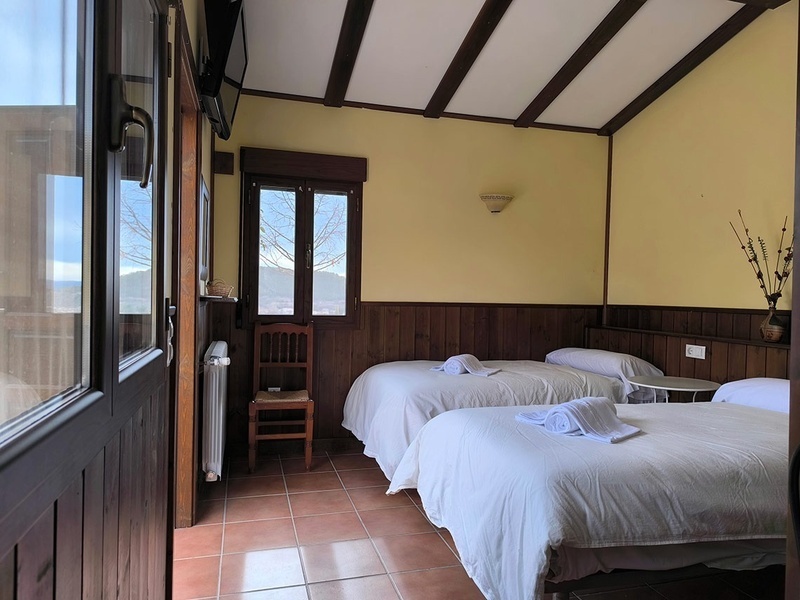 Bungalows - a bedroom with two beds and a chair