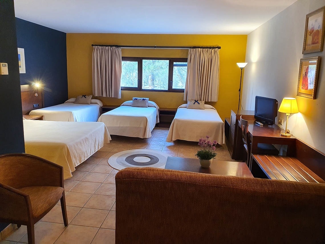 una habitación con tres camas y una televisión