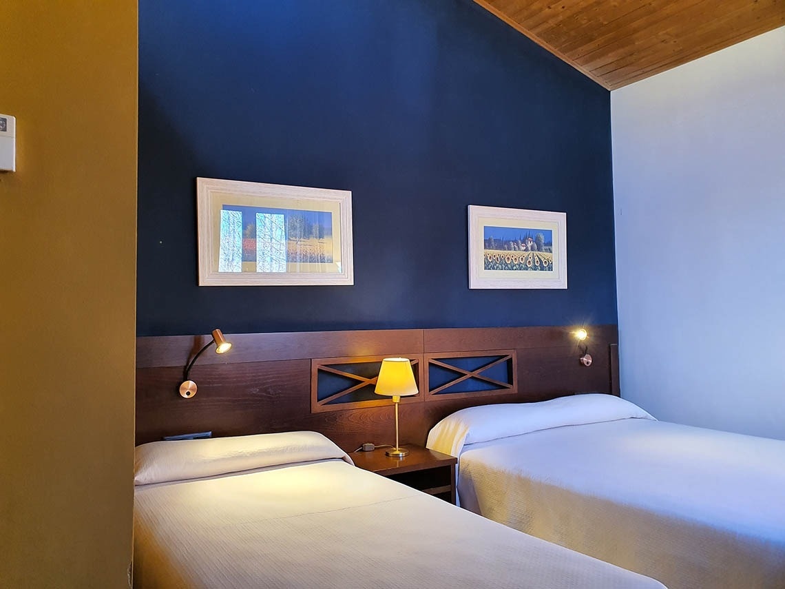 una habitación con dos camas y dos cuadros en la pared