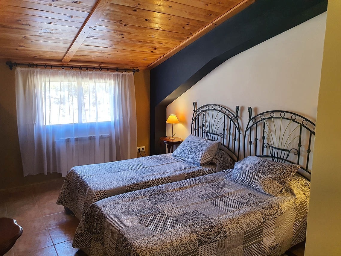 una habitación con dos camas y un techo de madera