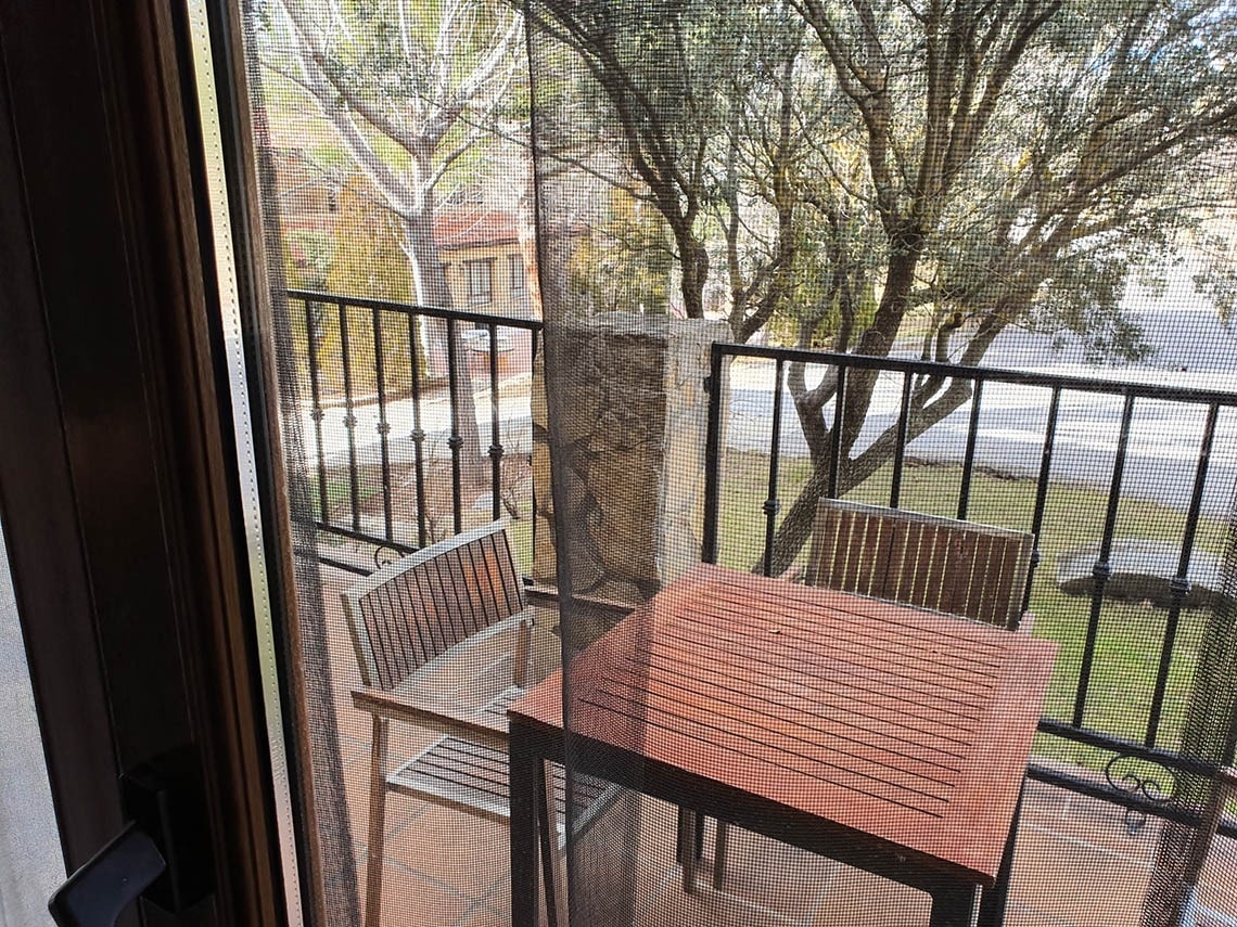 una mesa de madera y dos sillas en un balcón