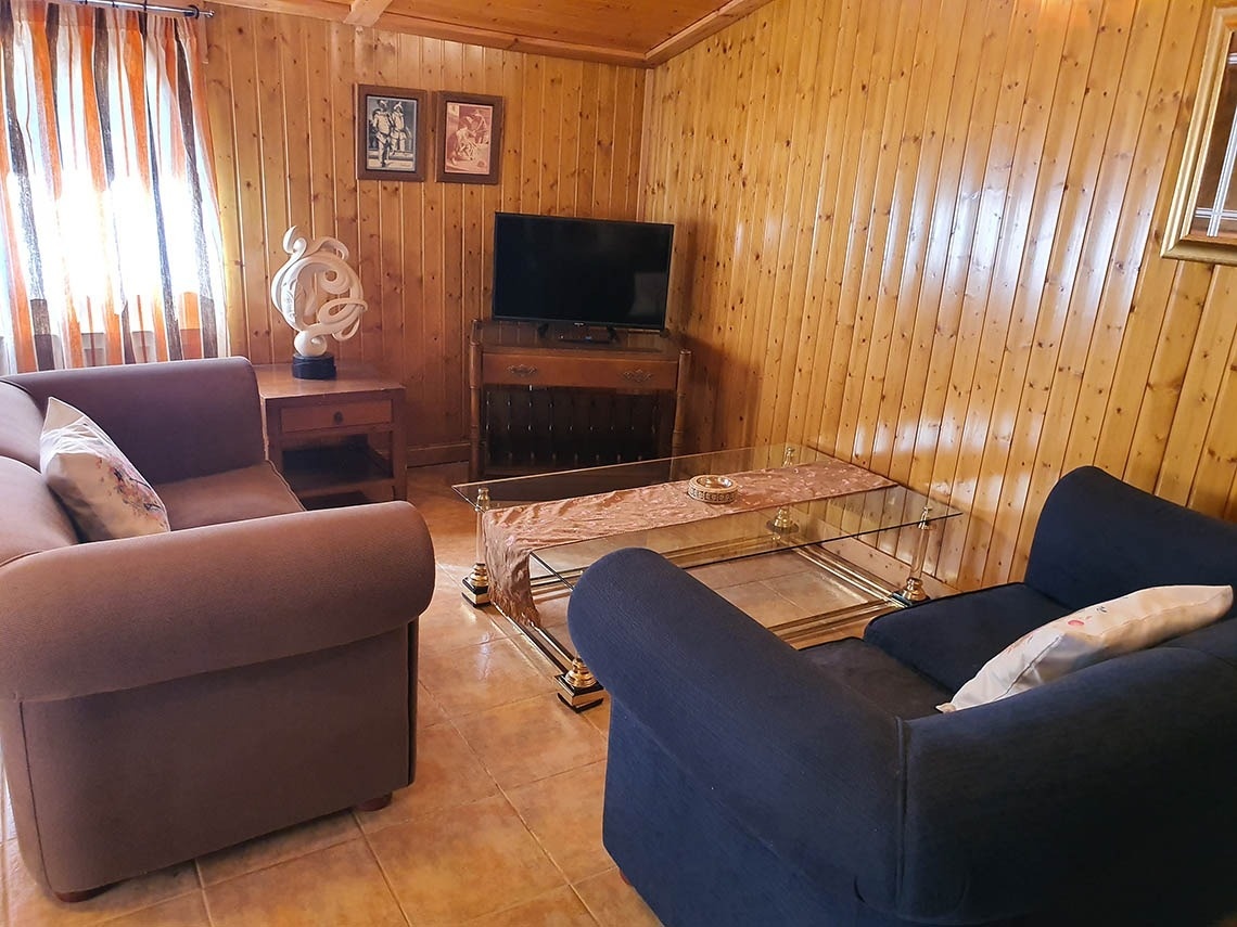 una sala de estar con un sofá y una silla y una televisión