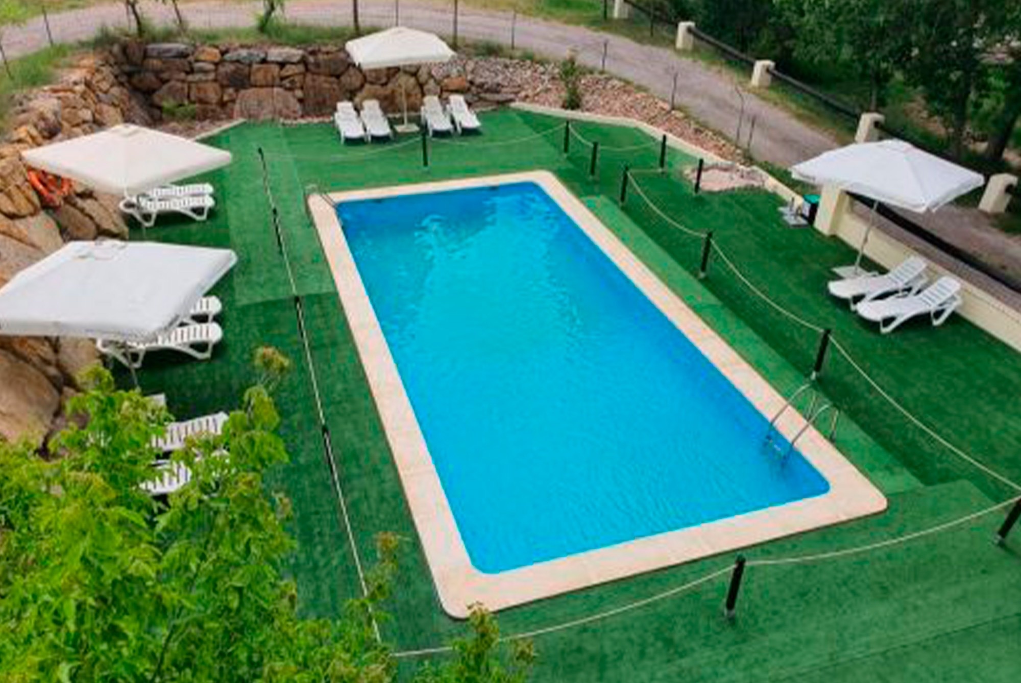 una piscina con escaleras y una casa en el fondo