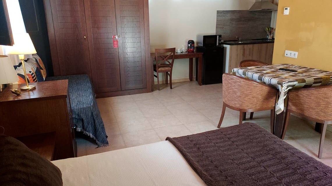 una habitación con una cama y una mesa y sillas