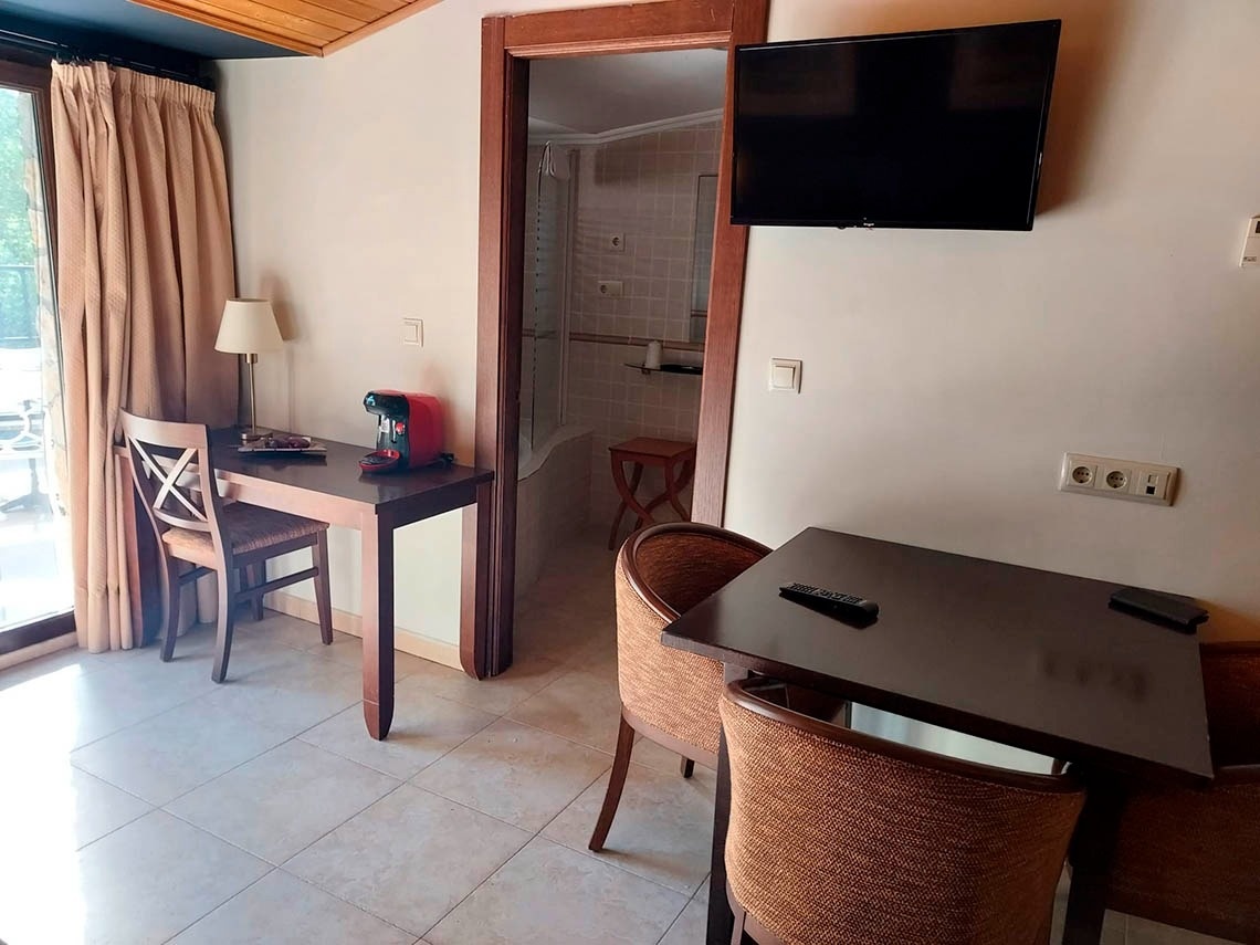 una habitación con una mesa y sillas y una televisión