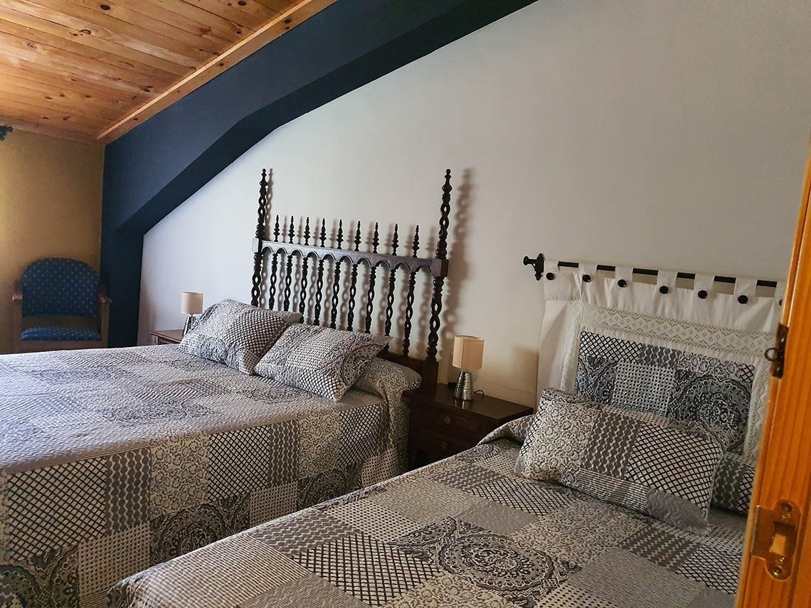 un dormitorio con dos camas y una silla