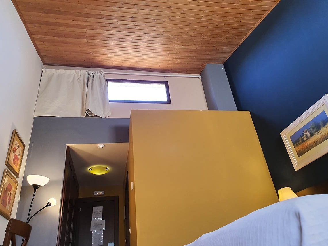 una habitación con paredes amarillas y un techo de madera