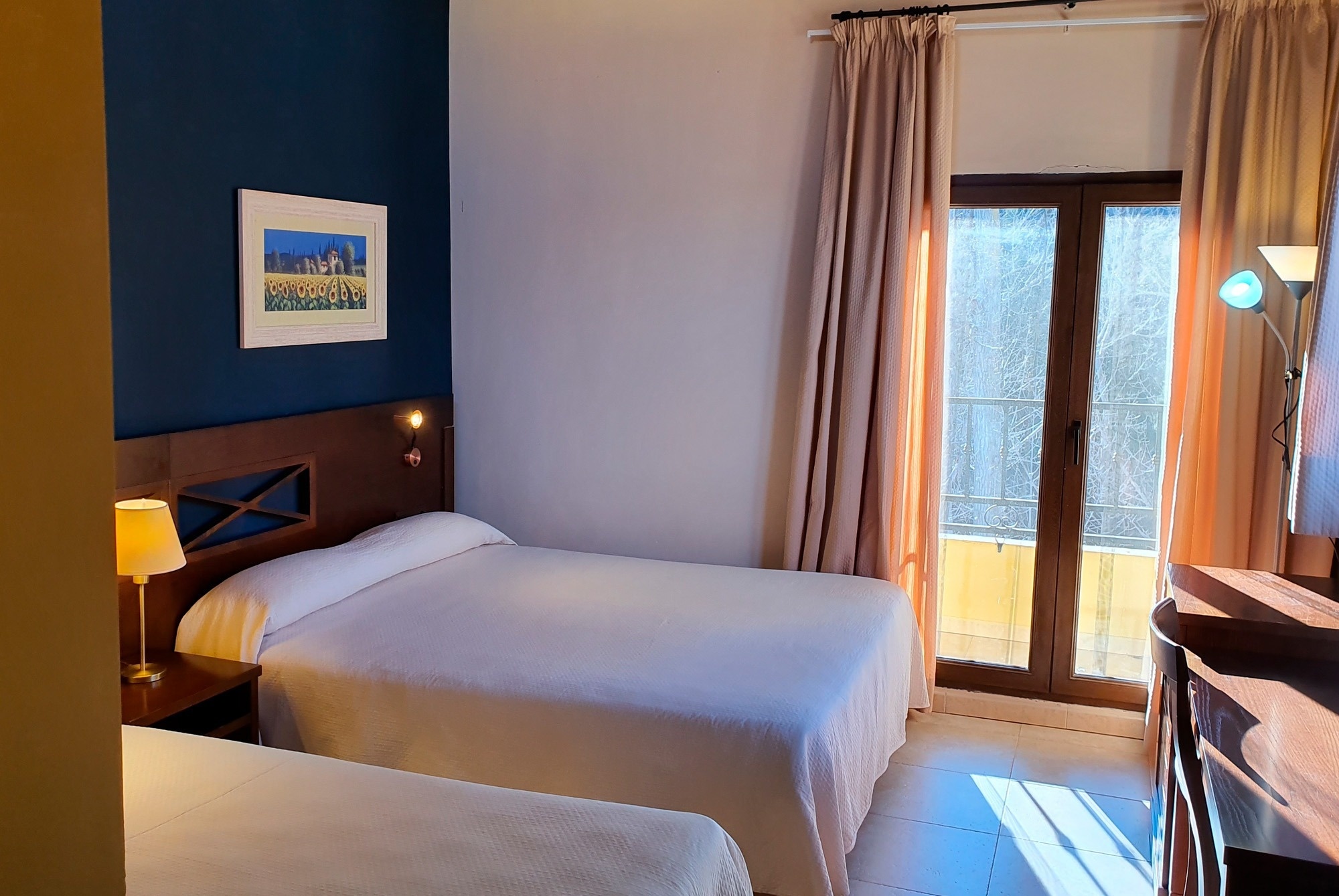 una habitación con dos camas y una pintura en la pared