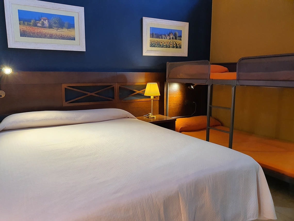 una habitación con una cama doble y dos literas