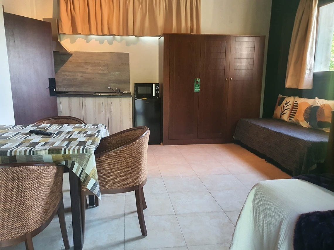 una habitación con una mesa y sillas y un refrigerador