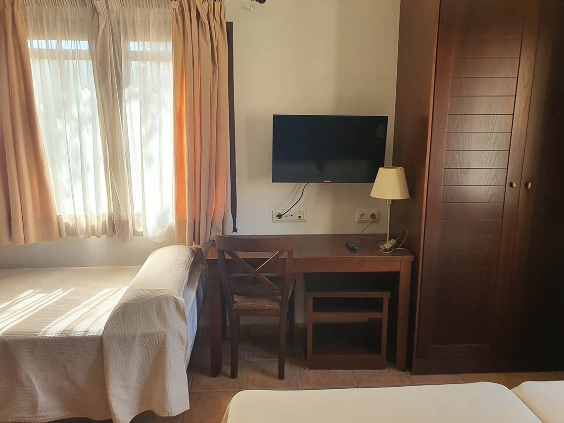 una habitación con dos camas y un televisor de lg en la pared