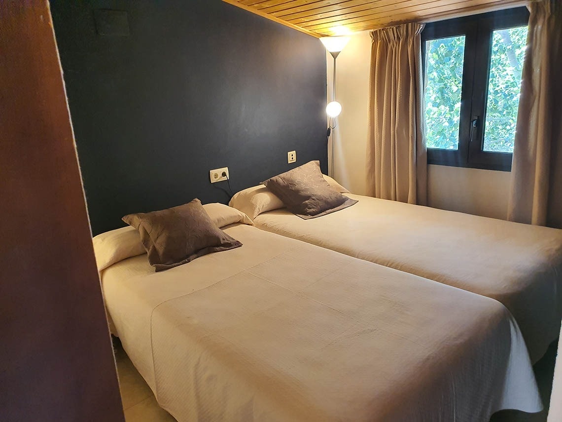 una habitación con dos camas y una ventana