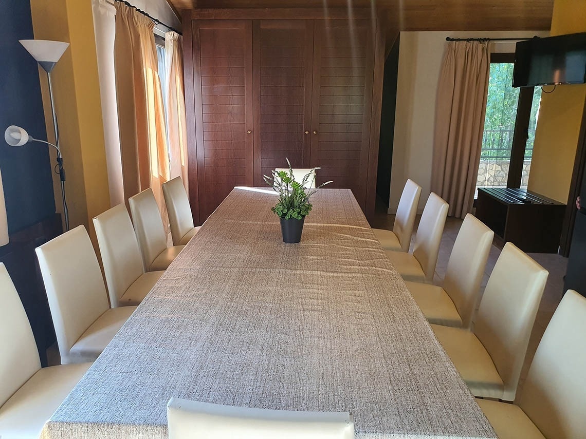 una mesa larga con sillas y una planta encima