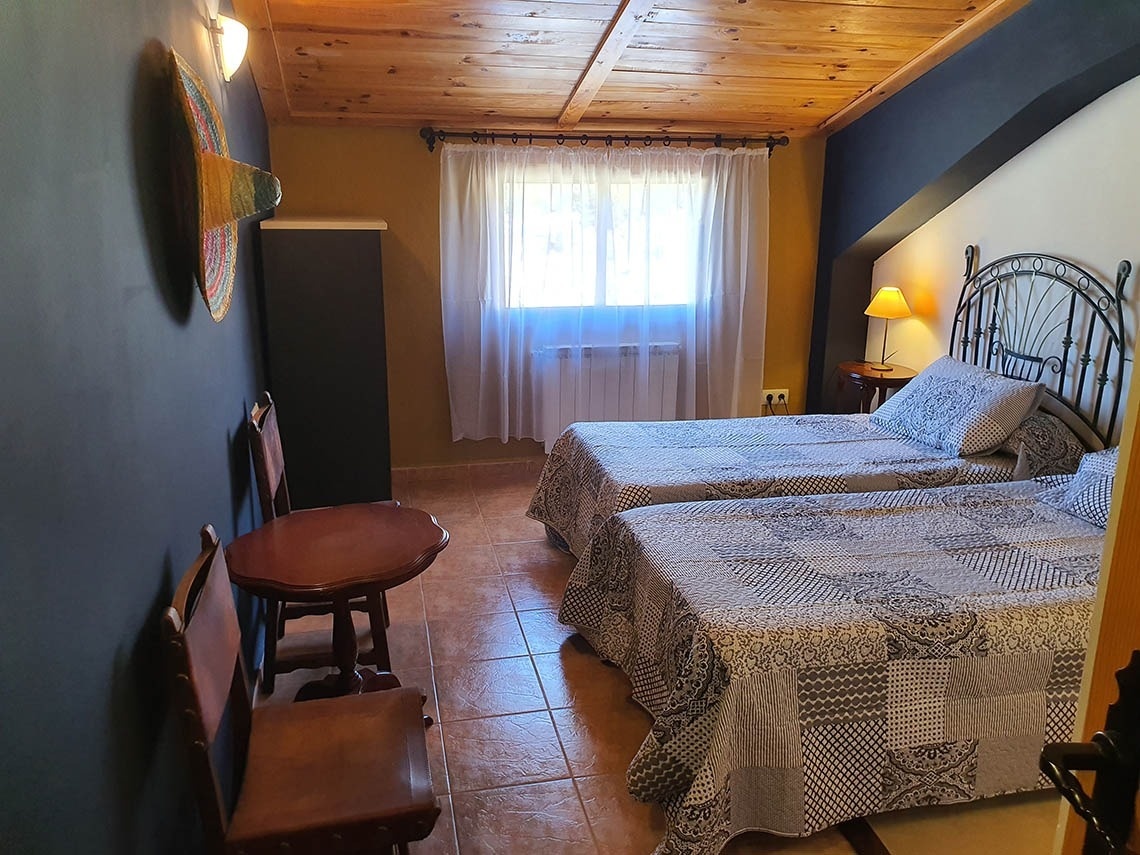 una habitación con dos camas y una mesa