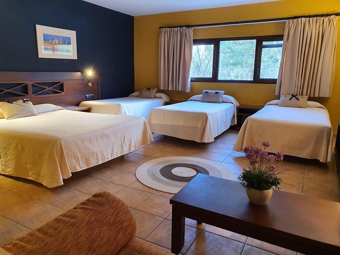 una habitación con tres camas y una ventana