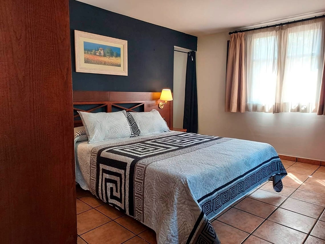 una habitación con una cama y una pintura en la pared