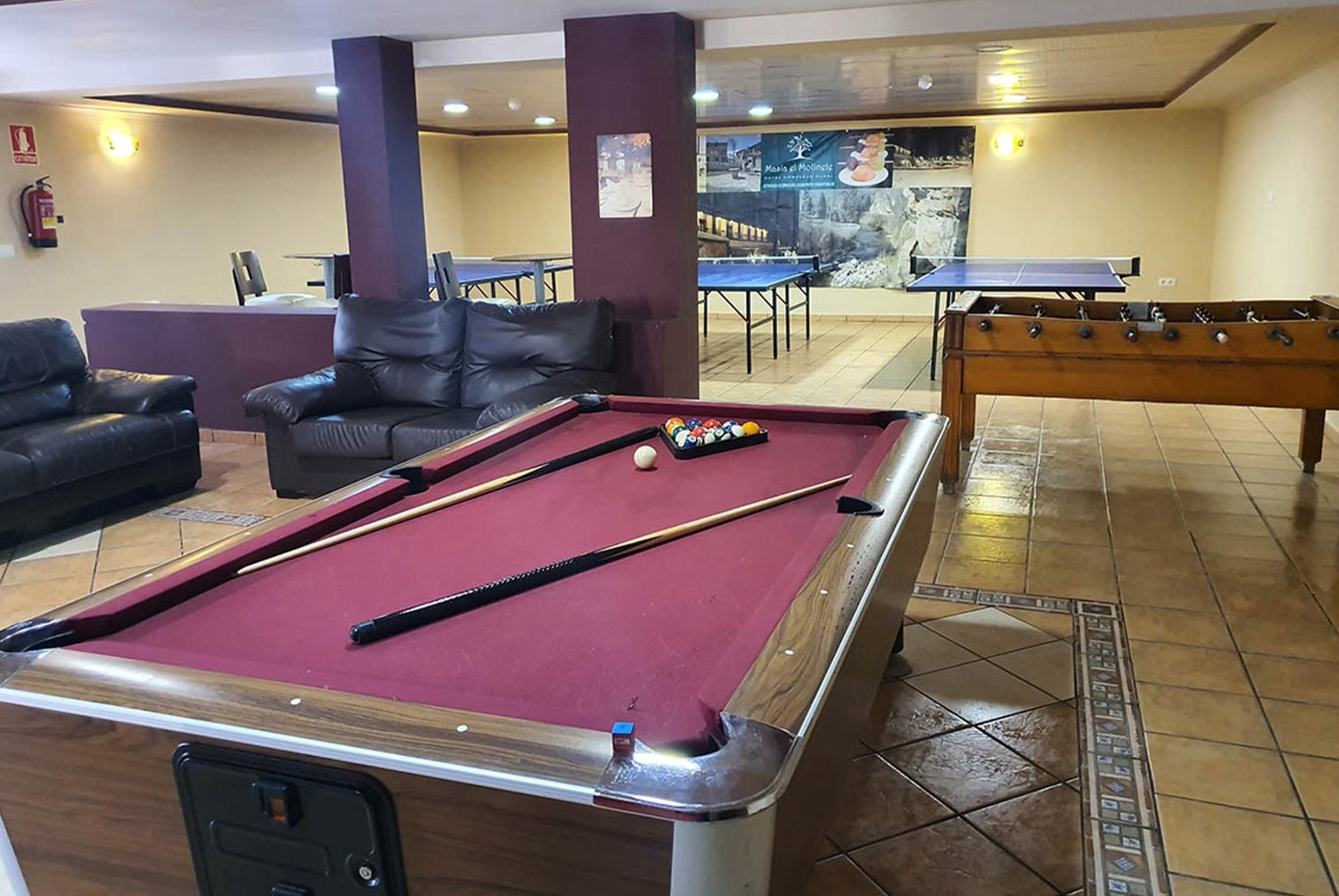 una sala de juegos con una mesa de billar y un sofá