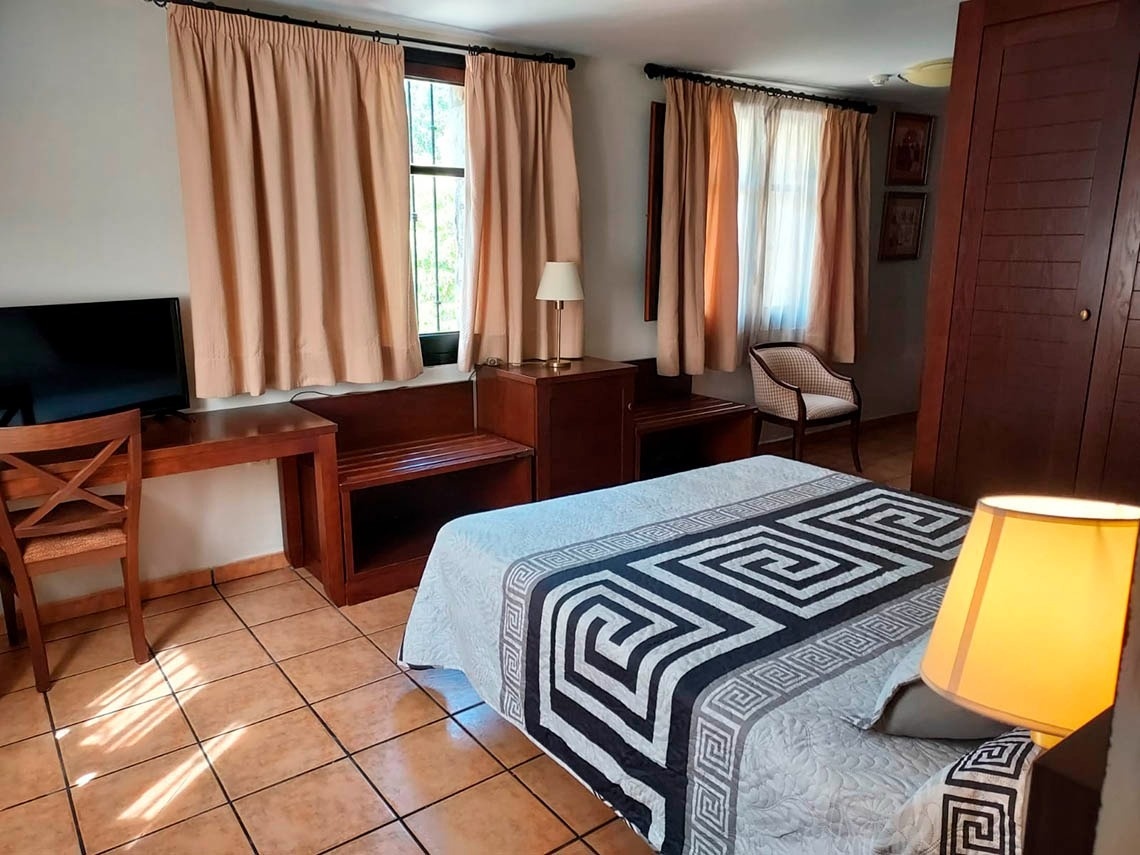 una habitación de hotel con una cama y una televisión